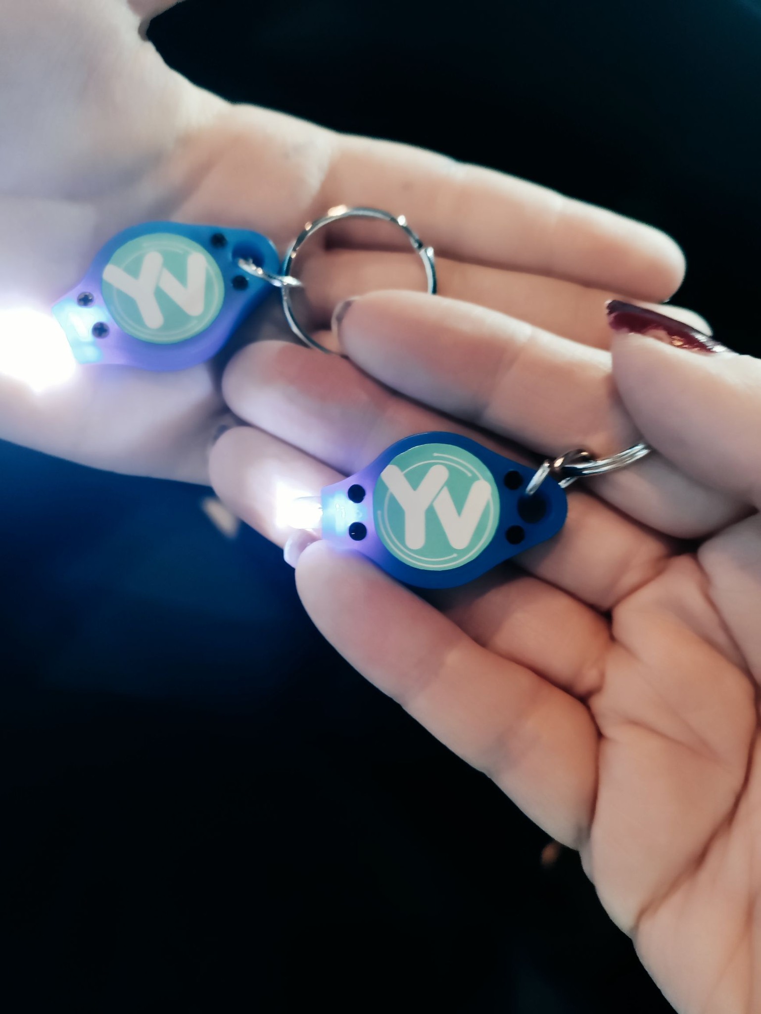 2 hands holding keyrings with 'YV' on them
