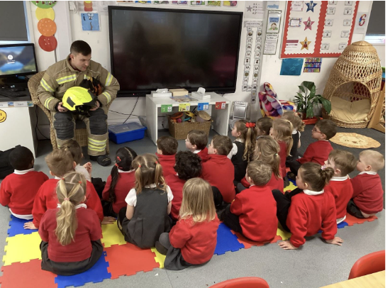 Students in a classroom listening to a talk from a fireman